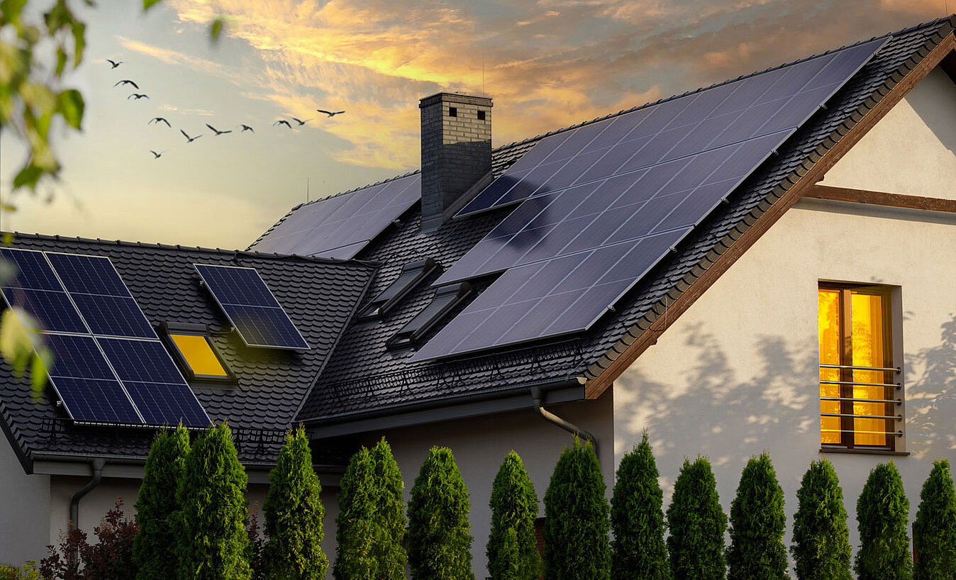 [Translate to Spanish:] Haus mit Photovoltaik-Anlage auf Dach im Abendrot